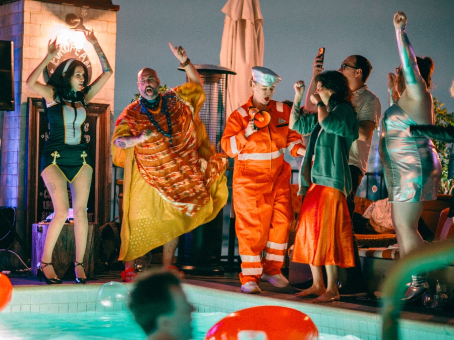 Costumed dancers on stage by the pool